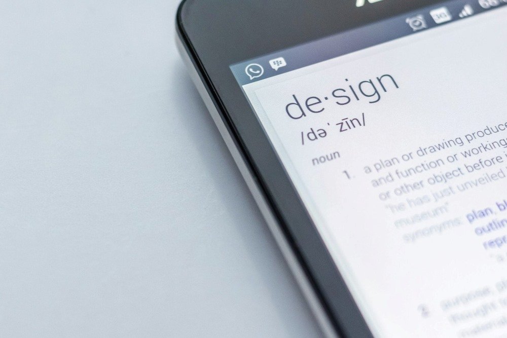 Close-up of a smartphone screen displaying the definition of the word 'design' with a sleek and minimal layout.